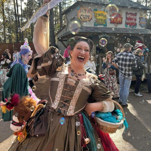Natalie Starr Storyteller ORF La Serenissima surrounded by bubbles and waving a fan